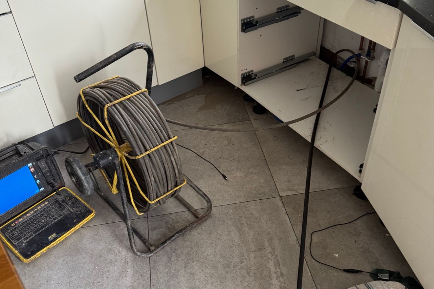 Leak detection equipment set up in a kitchen to investigate a hidden water leak.